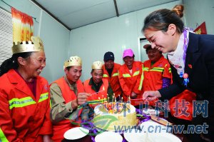 社區(qū)工作人員為集體過生日的三名環(huán)衛(wèi)工人點(diǎn)上生日蠟燭。 本報(bào)通訊員 趙松 攝